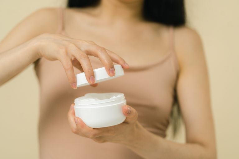 жінка відкриває крем SPF